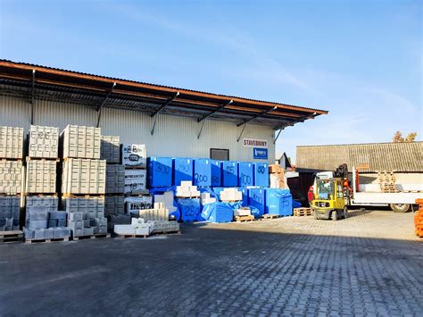 Zamestnanci nakladajú stavebný materiál na auto