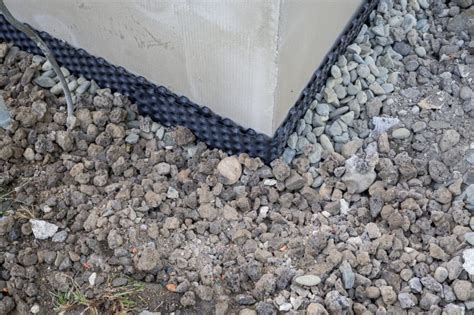 Skladovanie sivého polystyrénu na stavenisku pod plachtou