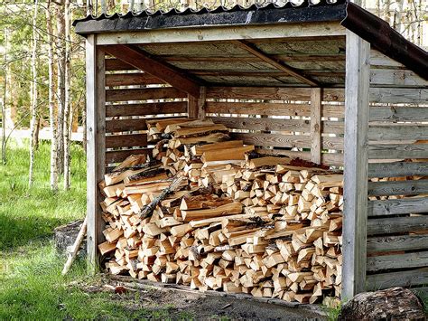 Drevené polená uložené pod prístreškom na sušenie