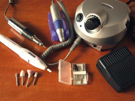 Ilustrácia elektrickej brúsky na nechty s rôznymi nadstavcami