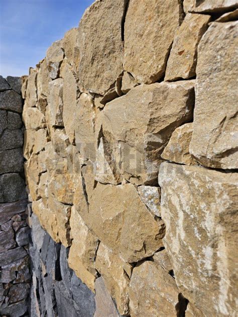 Kamenný obklad Rock Face v interiéri s drevenými prvkami