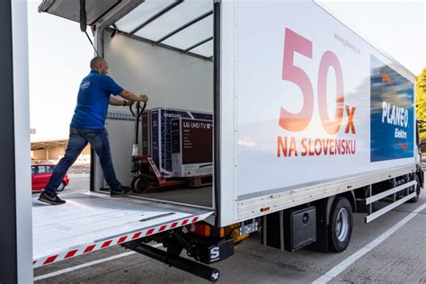 Personál pomáhajúci s nakládkou tovaru do auta