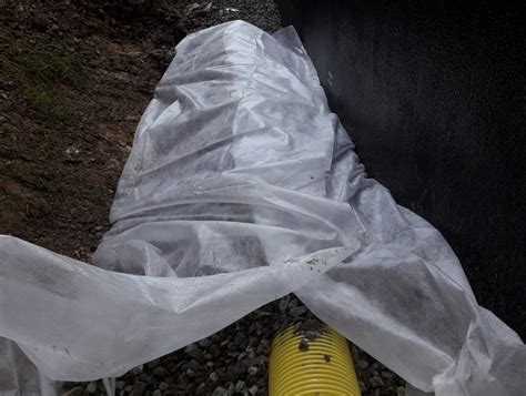 Inštalácia nopovej fólie a drenáže za palisádami