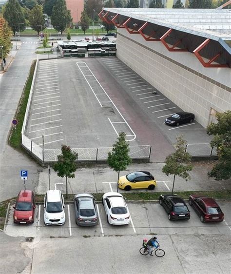 Zatrávnené parkovisko s vozidlami a zatrávňovacou dlažbou