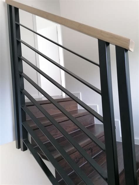 Kombinácia drevených stupňov a čierneho kovového zábradlia s tyčkami