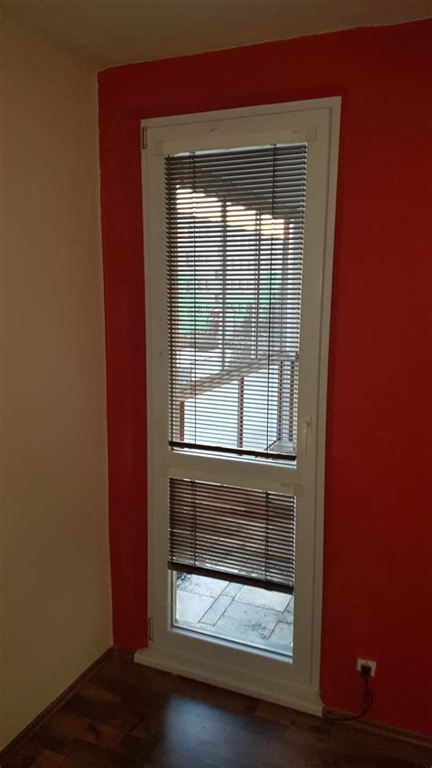 Tím technikov vykonáva montáž balkónových dverí