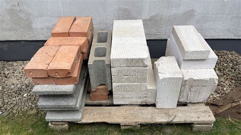 Rôzne druhy stavebných materiálov: tehly, betónové tvárnice a drevené trámy