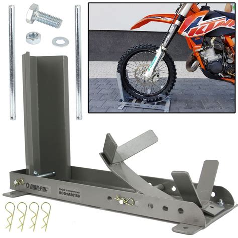 Detailný pohľad na uchytenie predného kolesa motocykla v oceľovom žlabe