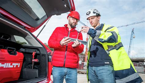 Obchodný zástupca Hilti diskutujúci so zákazníkom na stavbe