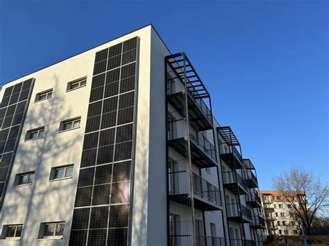 Moderná budova s označenými solárnymi panelmi symbolizujúcimi energetickú efektivitu