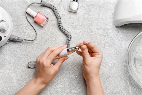Žena si brúsi päty s elektrickou brúskou