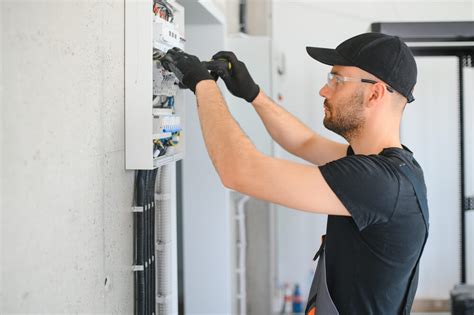 Elektrikár vykonávajúci inštaláciu elektrického rozvádzača