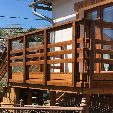 Drevené zábradlie na balkóne s kvetinami