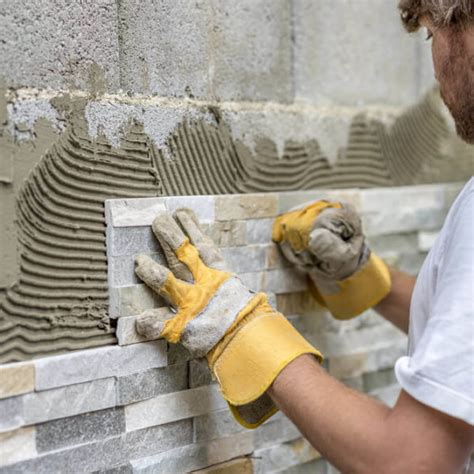 Detail krémového kamenného obkladu s tehlovou textúrou