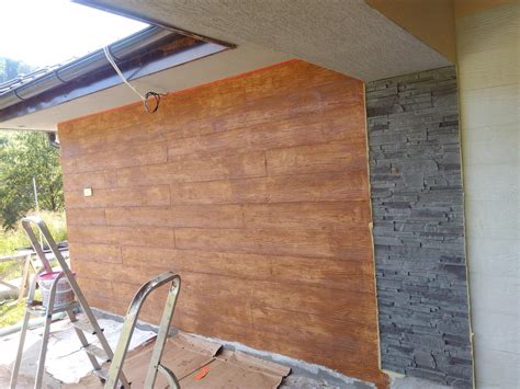 Detail plastového obkladu s imitáciou dreva na fasáde domu