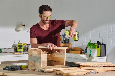 Muž pracujúci s aku vŕtačkou v exteriéri